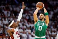 Jayson Tatum #0 of the Boston Celtics shoots the ball over Jimmy Butler #22 of the Miami Heat
